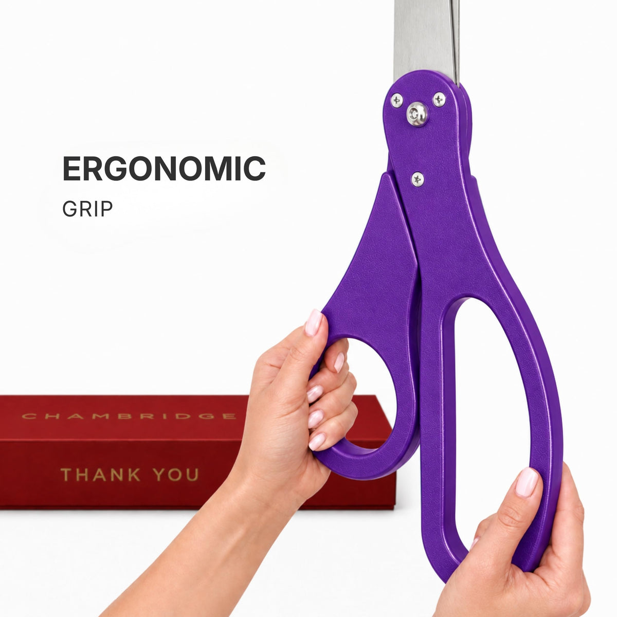 Hands gripping the ergonomic purple PVC handle of the 25-inch ceremonial scissors, Chambridge box in background