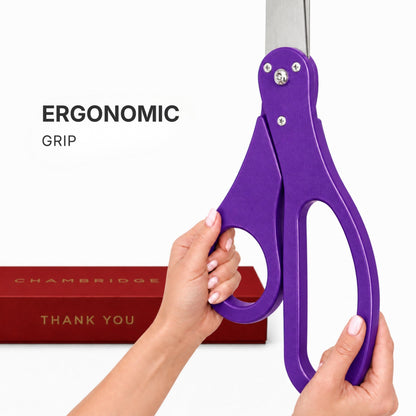 Hands gripping the ergonomic purple PVC handle of the 25-inch ceremonial scissors, Chambridge box in background