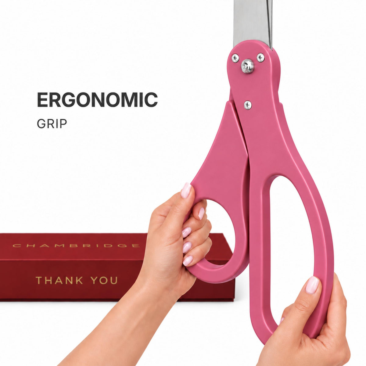 Scissors 25'' + Pink Ribbon — two hands gripping the pink ergonomic PVC handles, Chambridge Thank You gift box visible in
